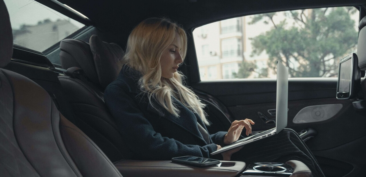 Business executive working in back seat of Mercedes chauffeur car